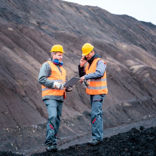 two men with protective gear consulting each other to represent the groundwater assessment and field investigation service.